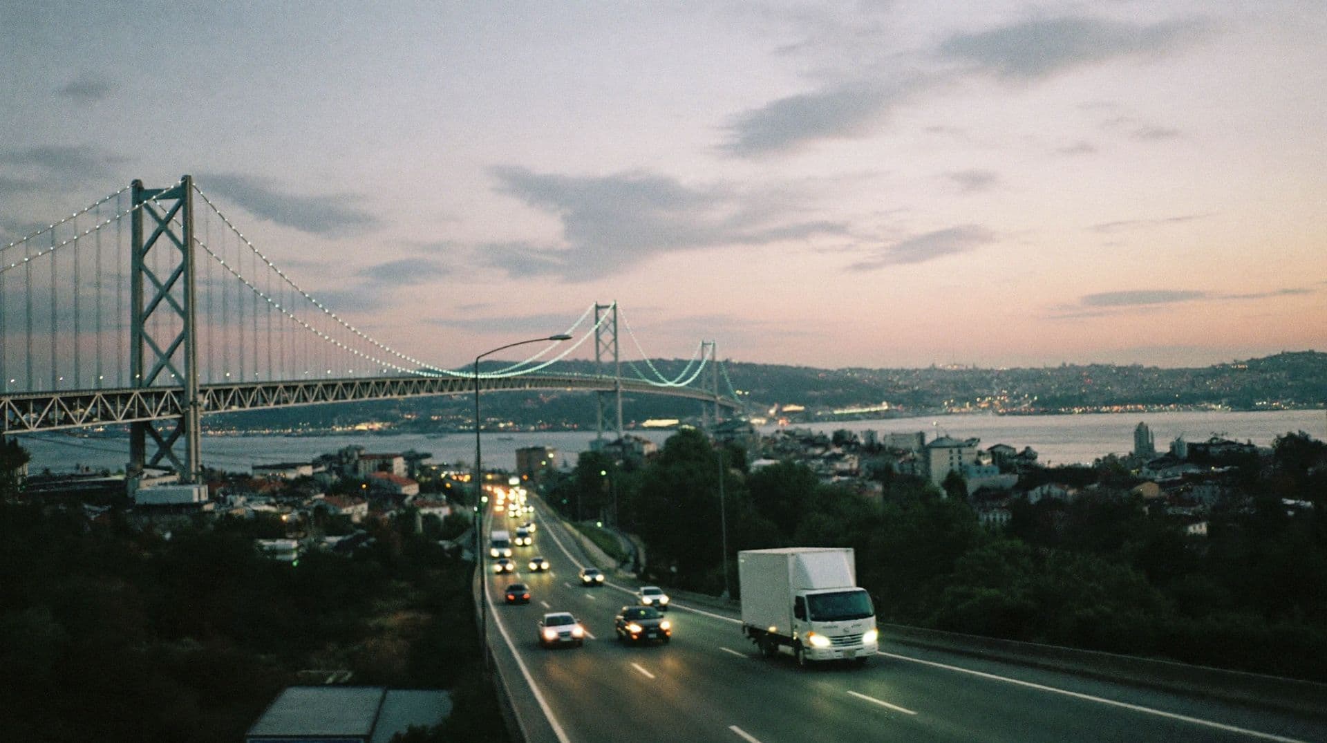 Alacakaranlıkta Boğaz köprüsüne akan trafik ve bir kamyon